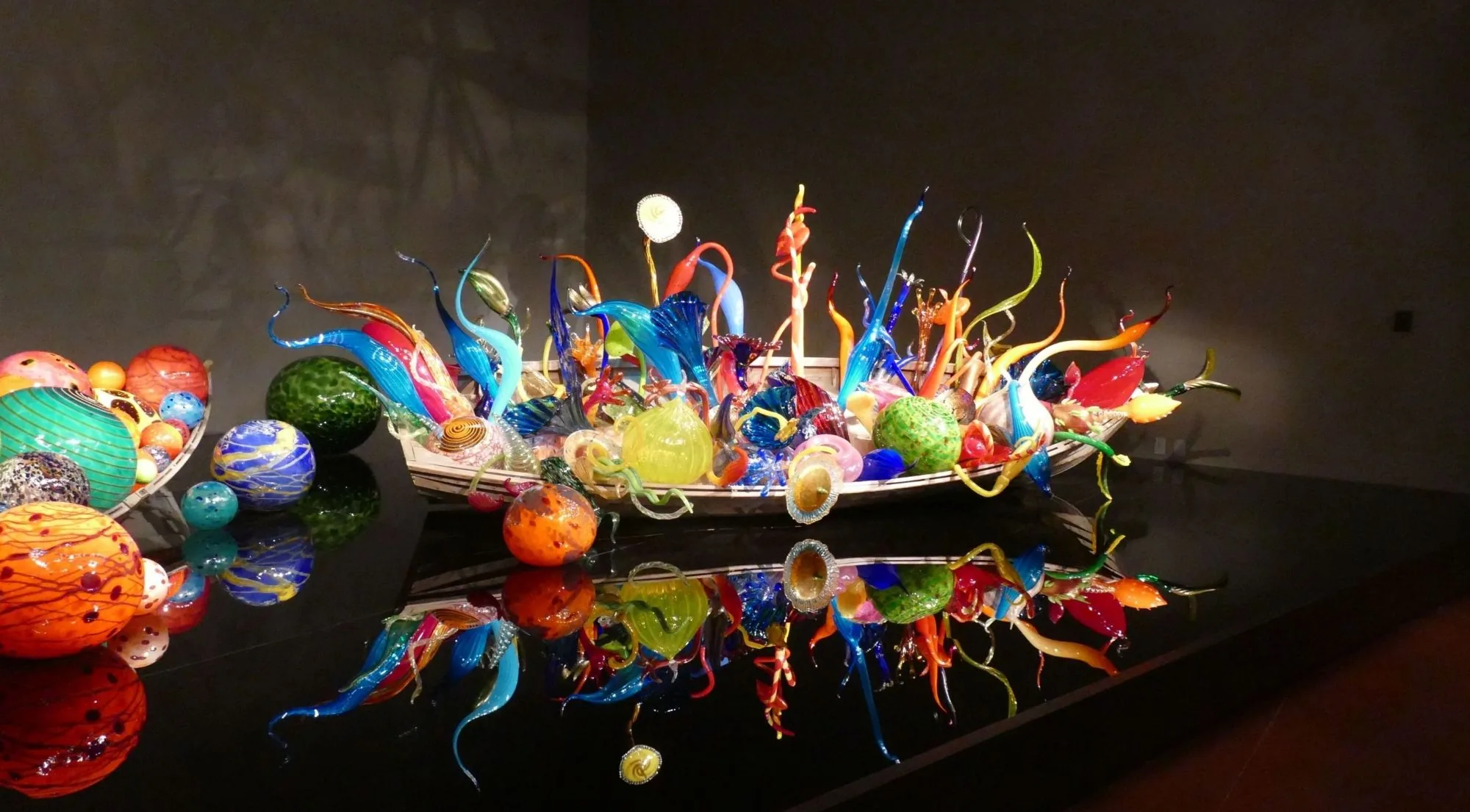 The Ikebana and Float Boats installation lit above its black reflecting floor
