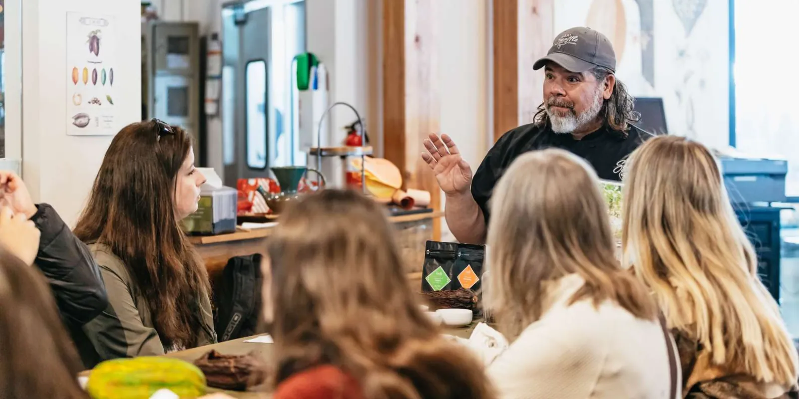 A market vendor explaining his products to the tour group across the counter