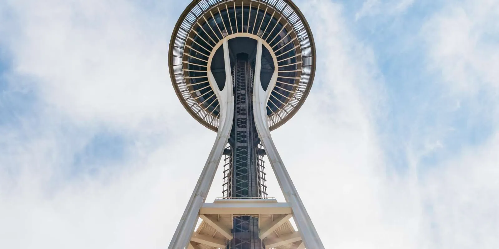 Looking straight up the Space Needle's legs to the observation deck against a bright sky