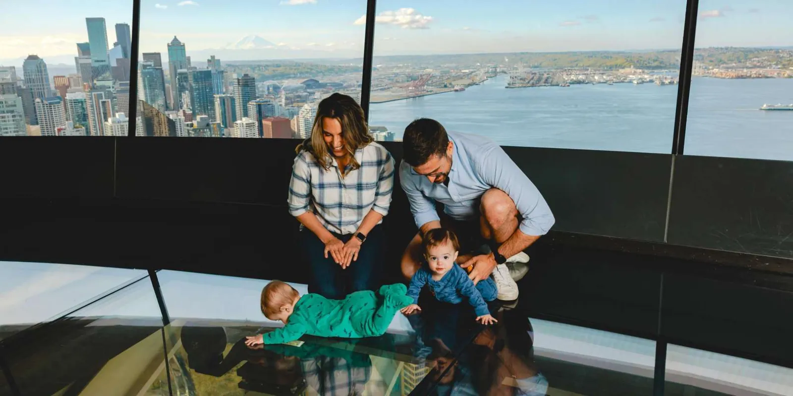 A family looking down through The Loupe, the Space Needle's revolving glass floor